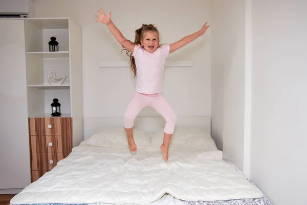 Счастливая Маленькая Блондинка Развлекается Дома Играет Прыгает Кровати — стоковое фото