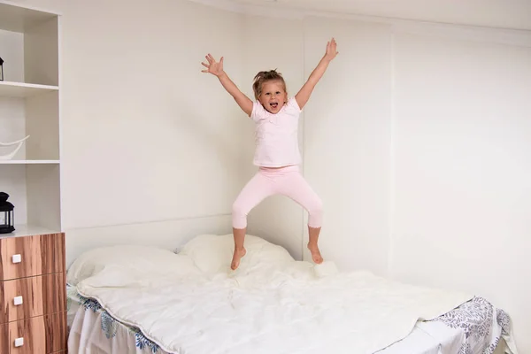 Веселая Милая Маленькая Девочка Прыгает Кровати Развлекаясь Дома — стоковое фото