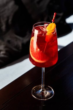 Kafedeki ahşap masada greyfurt ve çilekli aperol spreyli kokteyl.