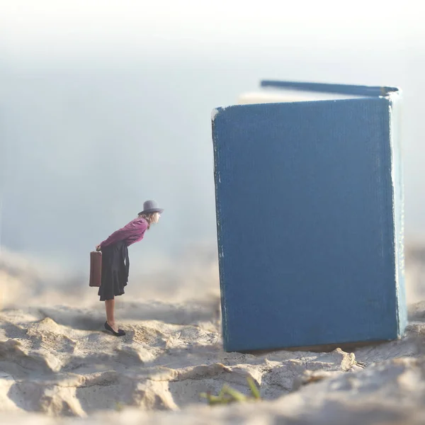 超现实的时刻 一个小女人谁梦想窥探在巨大的书籍页 — 图库照片