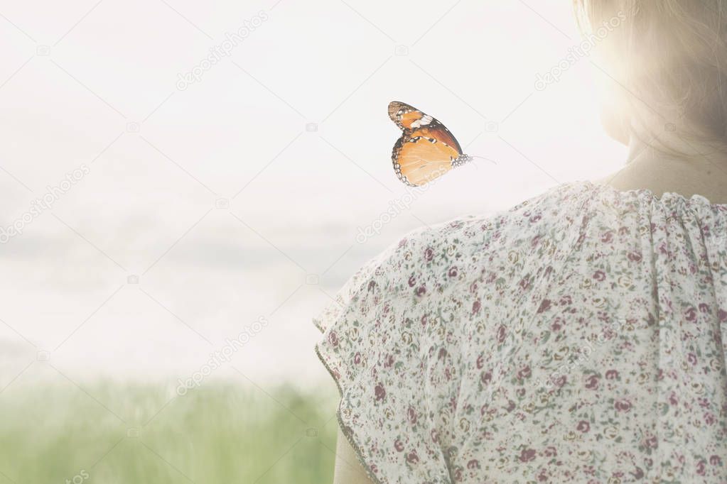 a colorful butterfly leans delicately on the shoulders of a girl