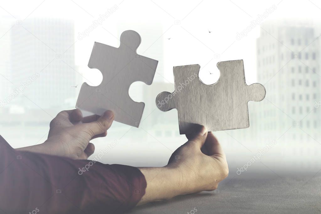 two hands join together two pieces of puzzle, concept of business and team wor