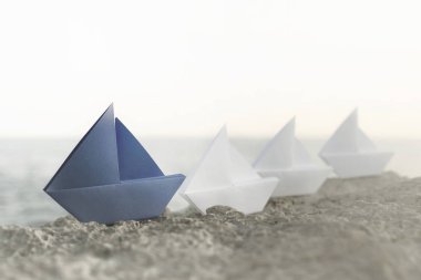 Mavi origami gemisi tüm beyaz gemilerin lideridir, iyi bir iş takım çalışması konseptidir.