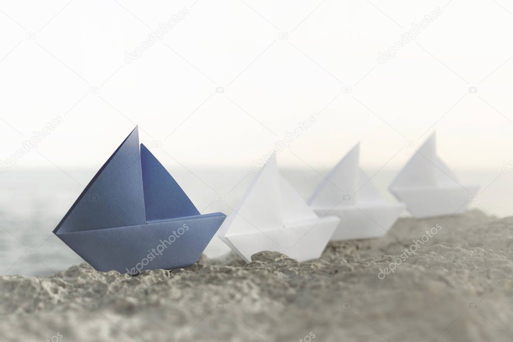 blue origami ship is the leadership of all white ships, a good business teamwork concept