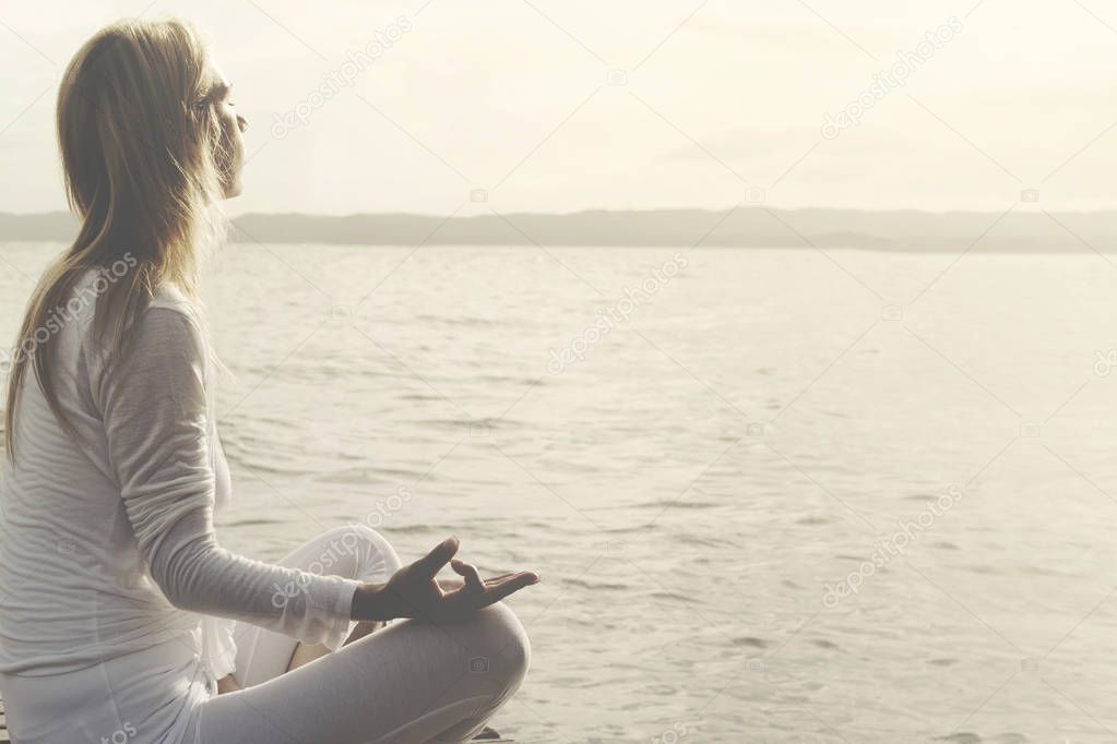 woman does yoga in front of an ocean view