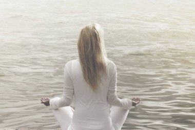 okyanus önünde yoga yaparken kadın