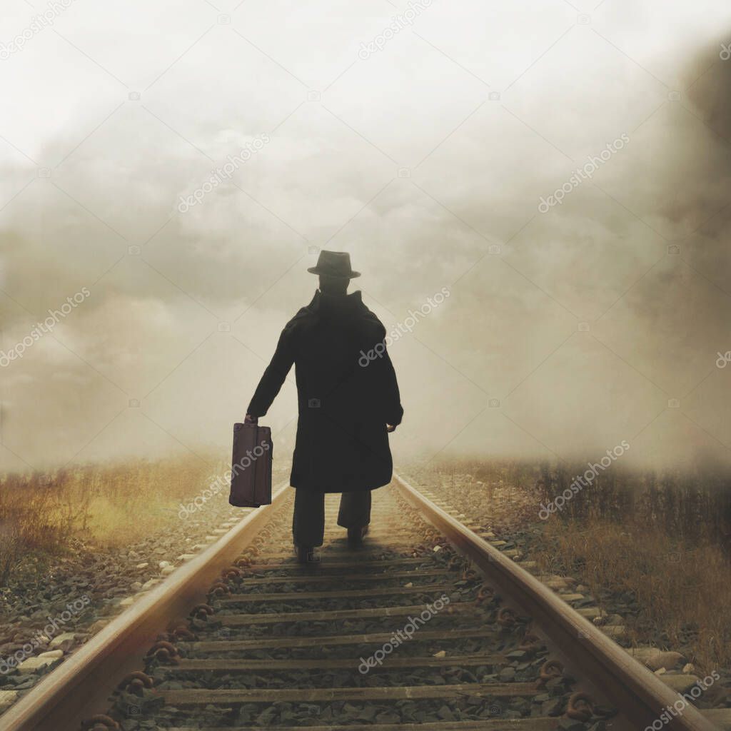 mysterious man walks with his suitcase on the tracks towards an unknown destination