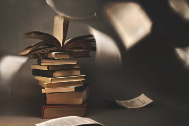 Sayfaların özgürce çırpındığı gerçeküstü klasik kitaplar yığını