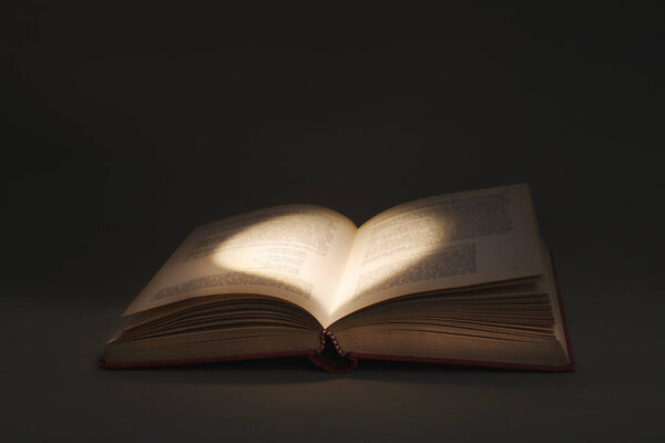 Mysterious light draws a heart in the pages of a book of love