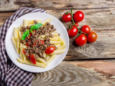 Makarna domates ve ahşap rustik arka plan üzerinde et. Üstten görünüm.