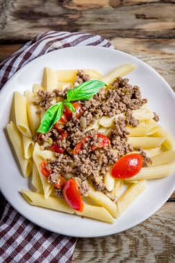 Makarna domates ve ahşap rustik arka plan üzerinde et. Üstten görünüm.