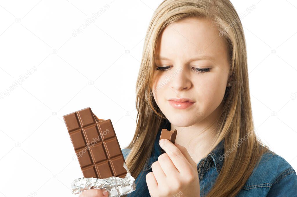 Girl biting a bar of chocolate