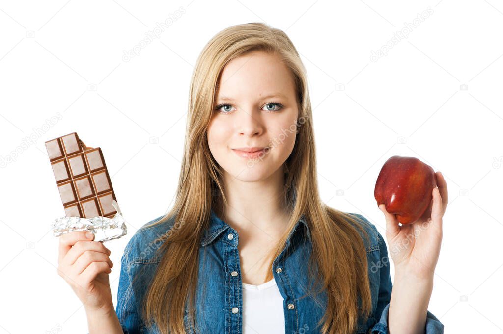 Girl holding an apple and a chocolate in her hands
