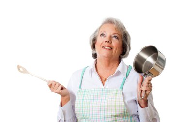 Ahşap kaşıklı ve tencereli yaşlı ev hanımı.