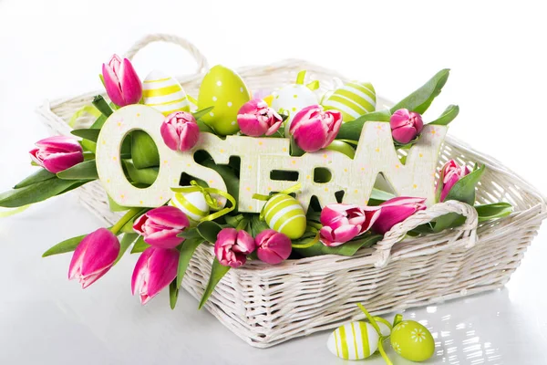 Colorful easter basket with easter eggs and tulips