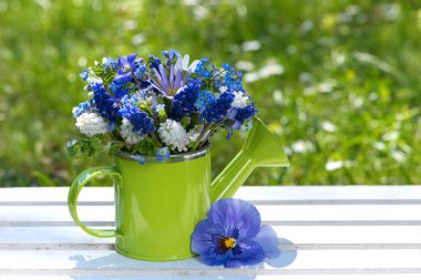 Bahçe masasında bahar çiçeği buketi