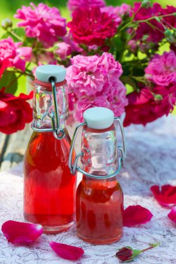 Bahçe masasında gül suyu şişeleri