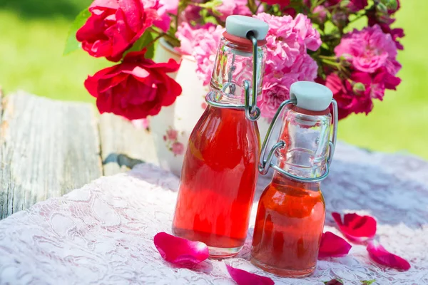 Rose Water Bottles Garden Table — Stock Photo, Image