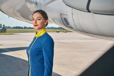 Üniformalı düşünceli bir kadın mesafeye bakıyor.