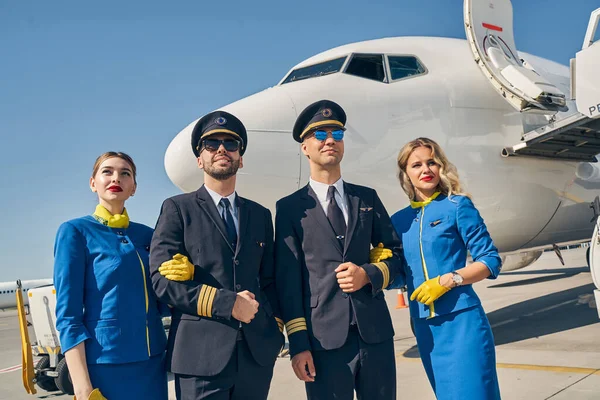 Aviões e aeromoças em pé no aeródromo — Fotografia de Stock