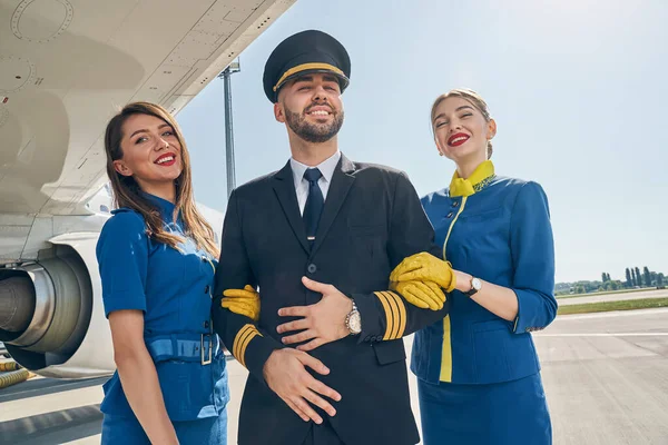 Modern young cabin crew smiling at the camera — Stock Photo, Image
