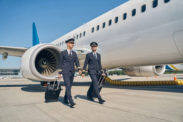 Elegantes jovens aviadores com sua bagagem ao ar livre — Fotografia de Stock