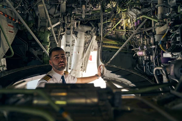 Focused young pilot inspecting an air vehicle — Stock Photo, Image