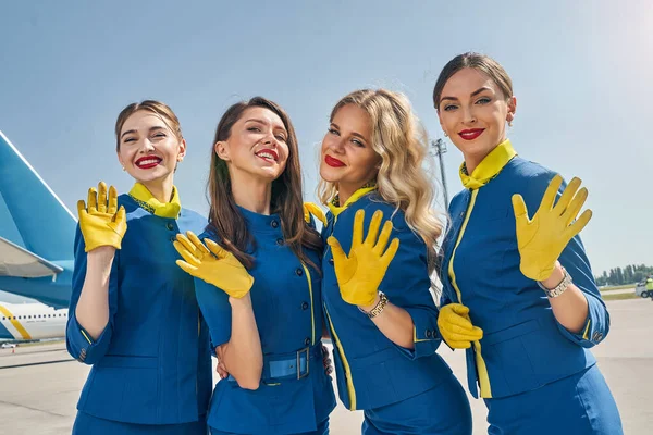 Attractive blonde stewardesses standing at the airfield — Stock Photo, Image