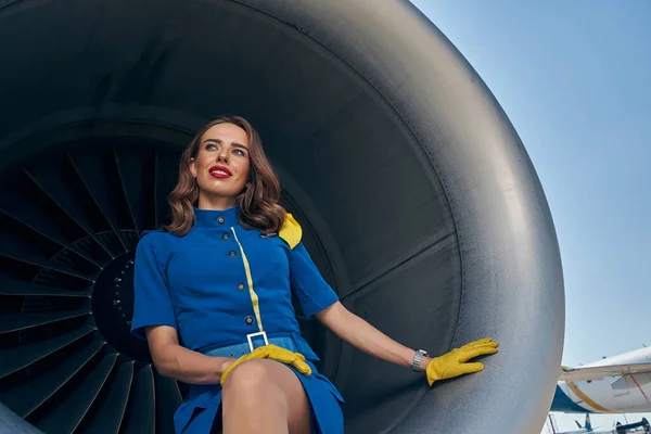 Elegant pretty lady sitting in an aircraft engine — Stock Photo, Image