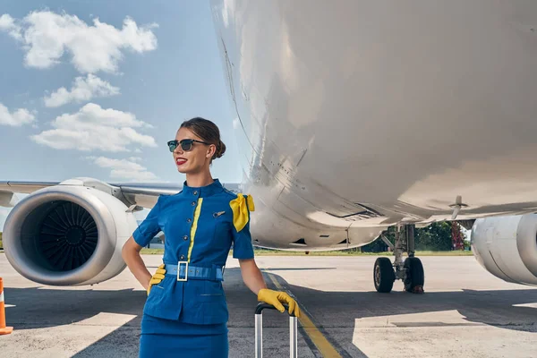 Sonriente empleado moderno de la aerolínea mirando a la distancia — Foto de Stock