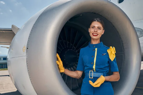 Usmívající se zaměstnankyně aerolinek se dívá do kamery — Stock fotografie