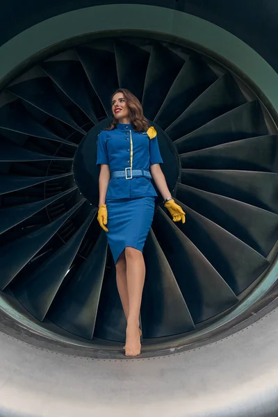 Mujer joven y agradable en uniforme mirando hacia otro lado — Foto de Stock