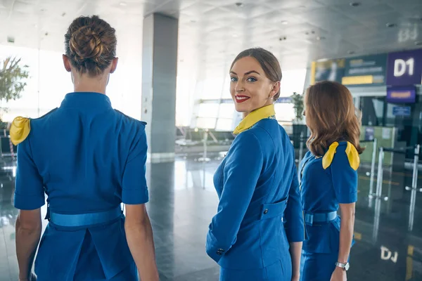 Vidám fiatal stewardess néz a kamerába — Stock Fotó