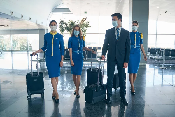 Elegante man en stewardessen met hun bagage — Stockfoto