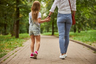 Küçük bir kızla dişi açık havada güzel sıcak havanın tadını çıkarıyor.