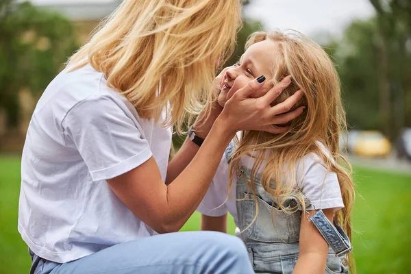 Krásná žena hraje s malou holčičkou v městském parku — Stock fotografie