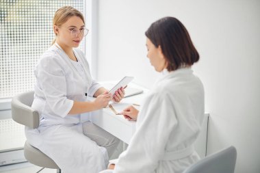 Müvekkilini dinleyen özenli bayan doktor.