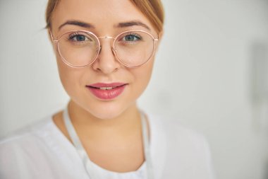 Gülümseyen sakin kozmetikçi kameraya poz veriyor.