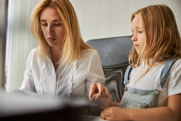 Charming blonde Caucasian female in white shirt sitting at the work desk — Stock Photo, Image