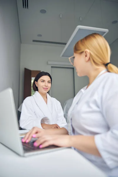 Cosmetologist sentado no laptop em seu escritório — Fotografia de Stock