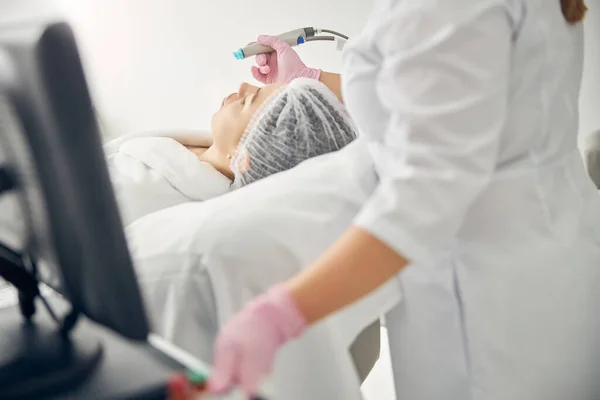 Kobieta lekarz leczenia kobiety za pomocą maszyny do piękna — Zdjęcie stockowe