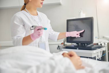 Bir elinde hidroterapi cihazı olan bir doktor.