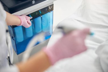 Sıhhiye eldivenli cildiyeci estetik ameliyata başlıyor.