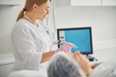 Elinde bir güzellik aleti olan bir doktor.