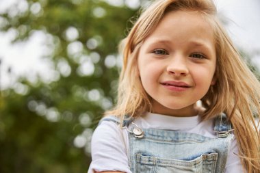 Şirin çocuk parkta sıcak havanın tadını çıkarıyor.