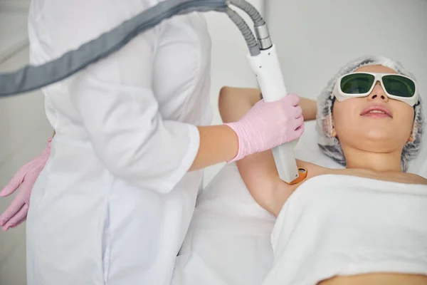 Arzt lenkt den Laserstrahl auf den Achselbereich des Patienten — Stockfoto