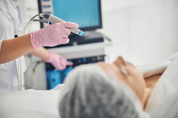 Médica certificada iniciando um tratamento de hidrodermoabrasão — Fotografia de Stock