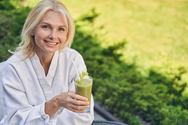 Smiling woman wearing white soft bathrobe standing in outside Royalty Free Stock Images