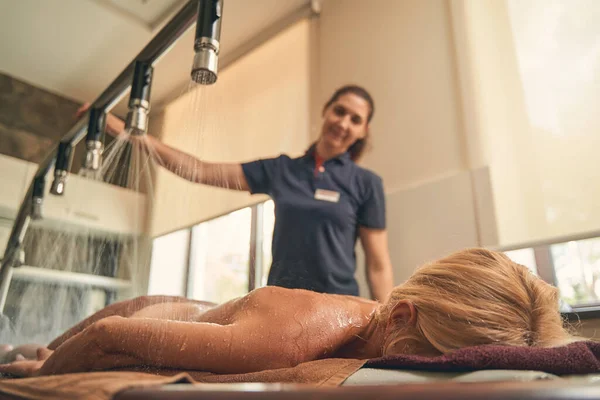 Frau liegt bei Wellness-Eingriff auf Holzschreibtisch — Stockfoto