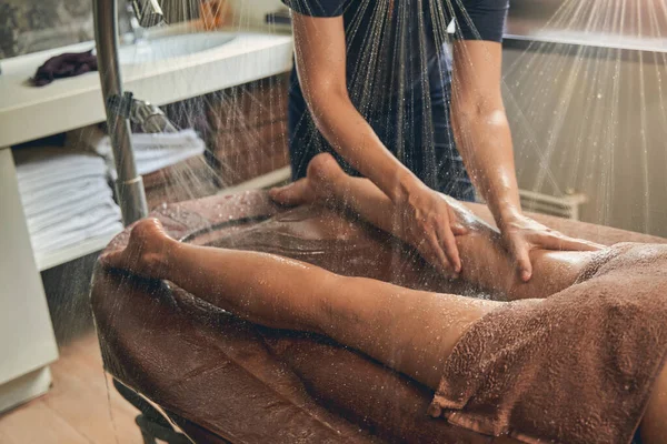 Visão horizontal do massagista massageando bezerro feminino — Fotografia de Stock